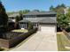 Rear exterior view of the home with a spacious backyard, a patio, and a large driveway at 9988 Devonshire St, Douglasville, GA 30135