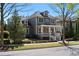Two-story home with a large front porch and well-maintained landscaping on a sunny day at 9988 Devonshire St, Douglasville, GA 30135