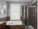 The tub sits next to the shower in this bathroom featuring custom tile work at 9988 Devonshire St, Douglasville, GA 30135