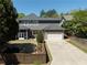 Rear exterior featuring a well-manicured yard, screened porch, and spacious driveway at 9988 Devonshire St, Douglasville, GA 30135