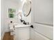 Chic bathroom with a modern vanity, stylish oval mirror, and attractive lighting at 1555 Olympian Sw Way, Atlanta, GA 30310