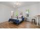 Cozy bedroom with hardwood floors, natural light, and a stylish modern light fixture at 1555 Olympian Sw Way, Atlanta, GA 30310