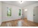 Bright bedroom featuring hardwood floors, two windows, and a closet at 1555 Olympian Sw Way, Atlanta, GA 30310