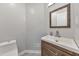 Powder room featuring modern vanity, mirror, and toilet at 2633 Jonesboro Rd, Fairburn, GA 30213
