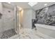Bathroom featuring marble tile, glass enclosed shower, and soaking tub at 2633 Jonesboro Rd, Fairburn, GA 30213