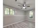Neutral bedroom with light-wood-style laminate flooring, ceiling fan and dual windows at 2633 Jonesboro Rd, Fairburn, GA 30213