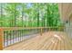Wide wooden deck features black metal railing overlooking lush wooded yard at 2633 Jonesboro Rd, Fairburn, GA 30213