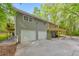 Back of home features two car garage, blue door, and elevated deck at 2633 Jonesboro Rd, Fairburn, GA 30213
