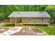 Charming home featuring a welcoming front porch and landscaped front yard in a serene setting surrounded by trees at 2633 Jonesboro Rd, Fairburn, GA 30213
