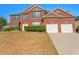 Inviting brick two-story home featuring a two-car garage and well-maintained landscaping at 3971 Busby Mill Ct, Ellenwood, GA 30294