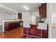 Open kitchen features hardwood flooring, stainless appliances, and raised breakfast bar seating at 3971 Busby Mill Ct, Ellenwood, GA 30294