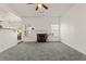 Bright living room with a fireplace, large windows, and modern ceiling fan at 3971 Busby Mill Ct, Ellenwood, GA 30294