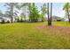 Expansive backyard with well-kept grass, tall trees, and neighboring homes in a serene setting at 4496 Sardis Church Rd, Buford, GA 30519