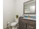 Well-lit bathroom featuring granite countertops and a decorative framed mirror above the vanity at 4496 Sardis Church Rd, Buford, GA 30519