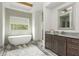 Bright bathroom featuring a modern tub, spacious vanity, and stylish mirror at 4496 Sardis Church Rd, Buford, GA 30519