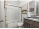 Bathroom boasting a granite countertop, framed mirror and tub with subway tiles and sliding door at 4496 Sardis Church Rd, Buford, GA 30519