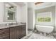 Bright bathroom featuring a modern tub, spacious vanity, and stylish mirror at 4496 Sardis Church Rd, Buford, GA 30519