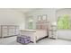 Bright bedroom with a queen bed, dresser, nightstand, and trunk offering stylish comfort and storage at 4496 Sardis Church Rd, Buford, GA 30519