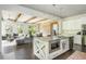 Open concept kitchen flowing into the living room with exposed wooden beams and brick wall at 4496 Sardis Church Rd, Buford, GA 30519