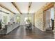 Open living room featuring dark hardwood floors, exposed beams and a brick accent wall at 4496 Sardis Church Rd, Buford, GA 30519