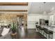 Living room view including kitchen island, brick wall, dining area, and staircase at 4496 Sardis Church Rd, Buford, GA 30519