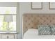 Bedroom detail of upholstered headboard and bedside table with window, creating a cozy setting at 4496 Sardis Church Rd, Buford, GA 30519