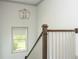 Staircase area featuring a modern chandelier, a sunlit window view, and decorative railing at 4496 Sardis Church Rd, Buford, GA 30519