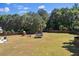 Large, grassy backyard features a wooden play set and trampoline, bordered by a wood fence at 524 Trousseau Ln, Mcdonough, GA 30252