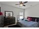 Well-lit bedroom with a ceiling fan and a dresser with a mirror at 524 Trousseau Ln, Mcdonough, GA 30252