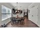 Open dining space with sleek black table, modern lighting, and access to the kitchen and pantry at 524 Trousseau Ln, Mcdonough, GA 30252