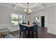 Dining area with a view showcasing a coffered ceiling, modern chandelier, marble table, and stylish decor at 524 Trousseau Ln, Mcdonough, GA 30252