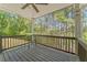 This home features a spacious back porch with wood flooring, ceiling fan, and a view of a beautiful wooded lot at 550 Vinings Springs Se Dr, Mableton, GA 30126