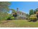 Spacious backyard view of white two-story home featuring a deck and lush green lawn at 550 Vinings Springs Se Dr, Mableton, GA 30126