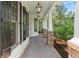 Charming front porch featuring brick flooring, white columns, and classic exterior lighting at 550 Vinings Springs Se Dr, Mableton, GA 30126
