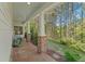 Inviting front porch with brick flooring and columns, overlooking a lush green landscape at 550 Vinings Springs Se Dr, Mableton, GA 30126
