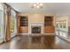 Spacious living room featuring a fireplace flanked by built-in shelving, with hardwood floors at 550 Vinings Springs Se Dr, Mableton, GA 30126