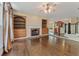 Sunlit living room with hardwood floors, fireplace, built-ins and views to the kitchen and staircase at 550 Vinings Springs Se Dr, Mableton, GA 30126