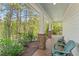 Covered front porch with brick columns, red brick paving, and a seating area at 550 Vinings Springs Se Dr, Mableton, GA 30126