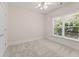 Bright bedroom with neutral carpet, ceiling fan, and a large window bringing in natural light at 550 Vinings Springs Se Dr, Smyrna, GA 30126