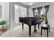 Elegant living room featuring a grand piano, complemented by large windows and stylish decor at 6062 Fielder Way, Douglasville, GA 30135