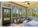 Relaxing screened-in porch featuring a ceiling fan, outdoor seating, and tranquil views of the lush, wooded backyard at 6062 Fielder Way, Douglasville, GA 30135