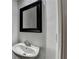 A cozy bathroom features a black framed mirror, modern faucet and simple vanity at 2272 Misty Brook Ct, Buford, GA 30519