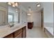 This bathroom features dual sinks, a separate tub and shower, and neutral tile flooring at 2272 Misty Brook Ct, Buford, GA 30519