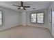 This bedroom features neutral carpeting, a modern ceiling fan, and a window providing natural light at 2272 Misty Brook Ct, Buford, GA 30519