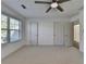 This bedroom features neutral carpeting, two windows providing natural light, and a modern ceiling fan at 2272 Misty Brook Ct, Buford, GA 30519