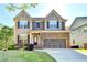 Attractive two-story house with lush landscaping, highlighting a modern architectural design at 2272 Misty Brook Ct, Buford, GA 30519