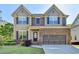 Charming two-story home featuring a well-manicured lawn and a brick-accented facade at 2272 Misty Brook Ct, Buford, GA 30519