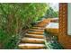 Landscaped backyard with wooden steps leading up to the house at 415 Oak Laurel Ct, Johns Creek, GA 30022