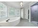 Bright bathroom with a large soaking tub, tiled floors and a glass shower at 415 Oak Laurel Ct, Johns Creek, GA 30022