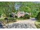 Brick home surrounded by trees and a well-manicured lawn at 415 Oak Laurel Ct, Johns Creek, GA 30022